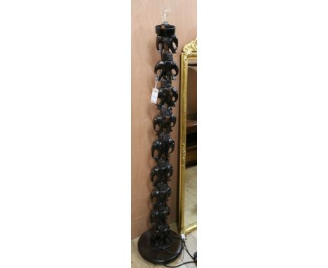 An African carved hardwood standard lamp Width of base 30cm
