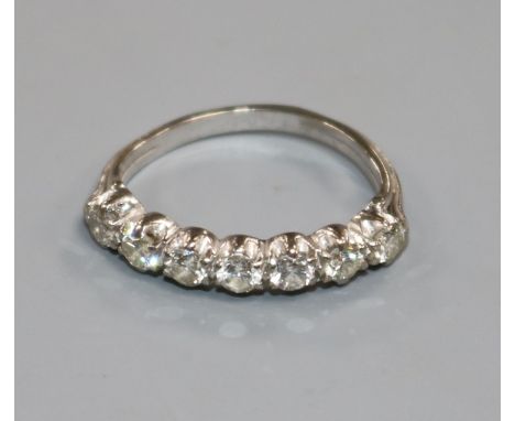 A white metal and seven stone diamond half hoop ring, size J.
