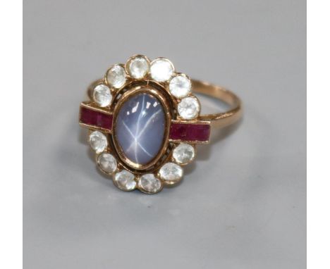 A yellow metal, cabochon star sapphire, ruby and white stone oval cluster ring, size P/Q.