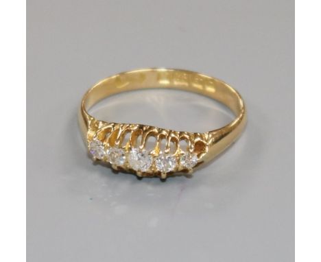 An early 20th century 18ct gold and graduated five stone diamond half hoop ring, size M.