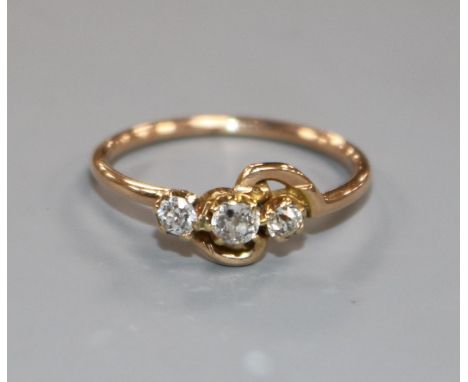 A yellow metal and three stone diamond crossover ring, size L.