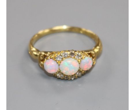 An Edwardian 18ct gold, white opal and diamond cluster ring, size M.