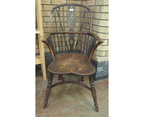 A 19th Century Windsor Elbow Chair with pierced splat and stick back, deep elm seat on turned legs united by crinoline stretc