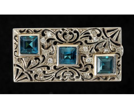 A Topaz and Diamond Brooch the pierced rectangular plaque set three step-cut blue topaz and eight-cut diamonds, stamped 750