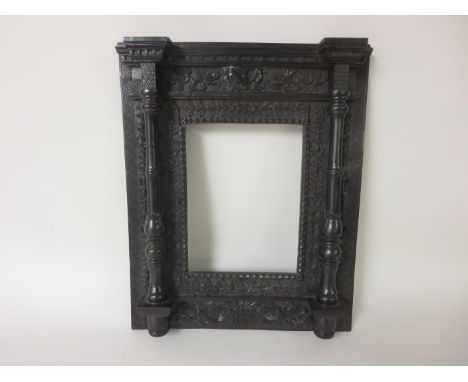 A 19th Century Indo-Chinese ebony Frame carved rosette, leafage scroll and trellis friezes, fronted by turned columns, 17 x 1