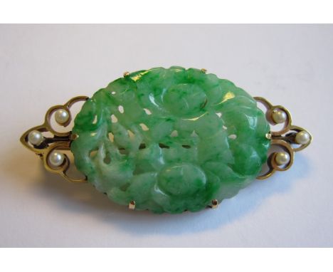 A Jade and Seed Pearl Brooch the oval carved and pierced jade between trios of pearls
