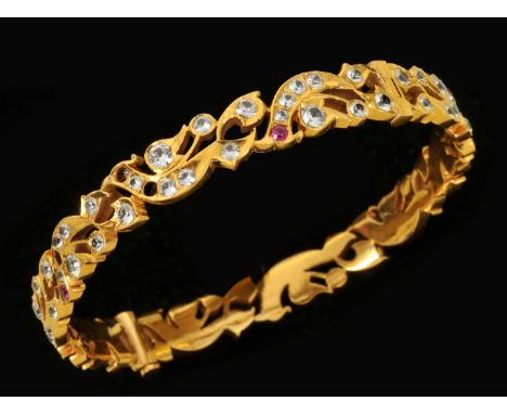 A hinged Bangle of pierced foliate design close-set brilliant-cut diamond and rubies, approx 35.40gms (some stones missing)