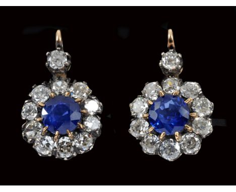 A pair of Sapphire and Diamond Earrings each claw-set circular-cut sapphire within a frame of ten old-cut diamonds with anoth