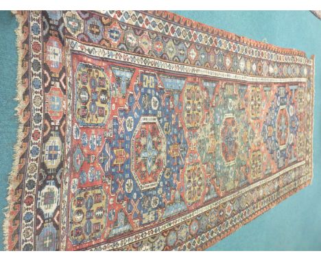 An antique bordered Soumak Carpet, the central field with gul motifs in blue and red, 11ft 4in x 6ft, very worn