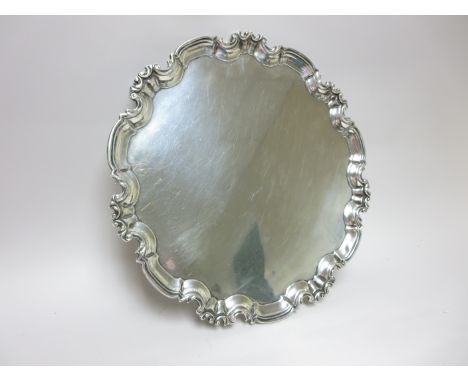 A George V silver shaped circular Salver with scroll border on four scroll feet, Sheffield 1917, 16in, 52oz