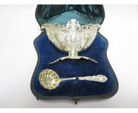 A Victorian silver oval Sugar Bowl with pierced rim, leafage scroll embossed, engraved crest, London 1896, and Sifting Ladle,