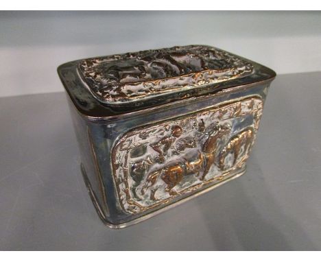 A silver plated on copper tea caddy, the front and lid decorated in high relief with scenes of horses and riders, key escutch