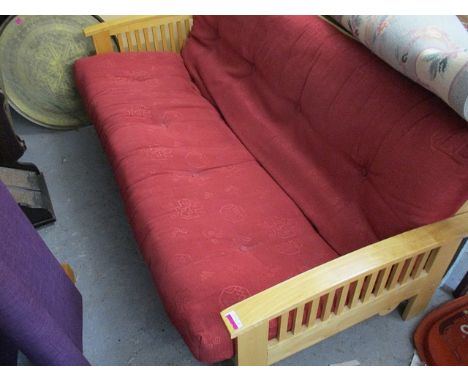 A modern, beech framed sofa bed with red upholstery and a modern purple upholstered bedstead and mattress, 54 wide