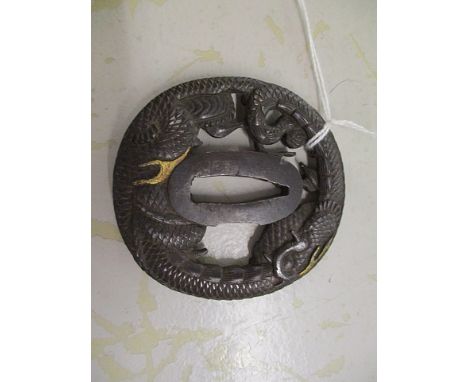A Japanese 18th century Tsuba decorated with dragons and gold highlights, the rim decorated with dragon scales, signed, 2 3/4