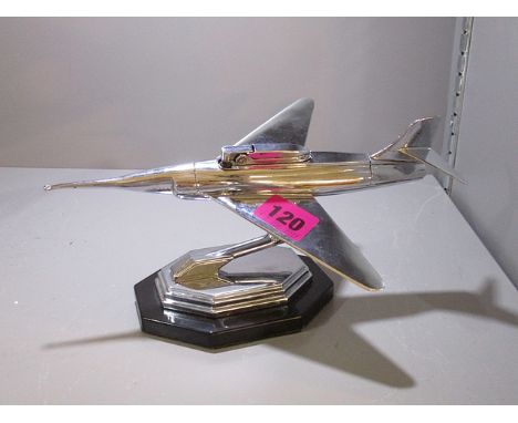 A chrome table lighter in the form of a jet plane on a pedestal foot, 4 1/2 high