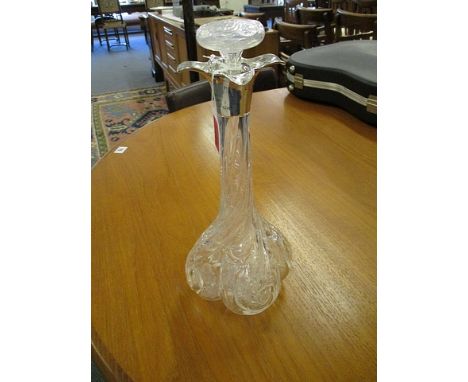 An Edwardian crystal decanter of lobed, square form with wrythen, foliate and floral cut decoration and a silver quatrefoil c