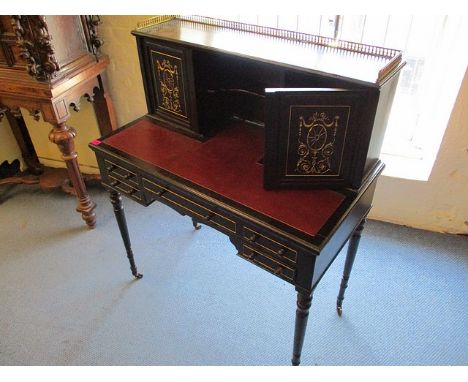 A late Victorian ebonized and gilt desk, the superstructure with a gilt metal gallery, over a shelf flanked by a pair of carv