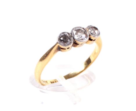 An early 20th century gold and diamond three stone ring. The graduated old-cut stones approx. 0.44cts total, millegrain set i