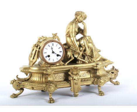 A French late 19th century gilt-metal striking mantel clock. Surmounted by a maiden emblematic of music, holding pipes, besid