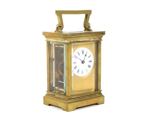 An early 20th century brass carriage clock. With white enamelled dial and black Roman numerals, within bevelled glass panels,