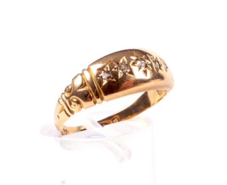 An Edwardian 18ct gold and small graduated diamond five stone gypsy ring. The tapering head between scroll chased shoulders, 