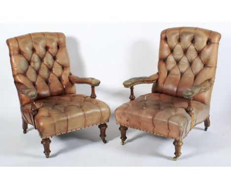 A pair of Victorian button back leatherette upholstered armchairs. Each with faded tan studded upholstery, with turned balust
