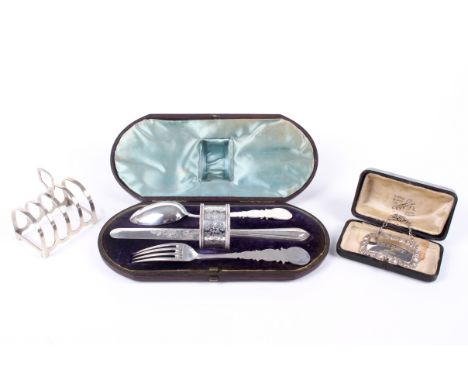 A silver toast rack, a cased christening set and a decanter label. The toast rack hallmarked Birmingham, 1933, the christenin