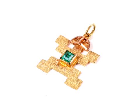 A vintage Inca/Mayan yellow metal and emerald pendant. Designed as a stylised god figure rub-over set at the centre with a sq