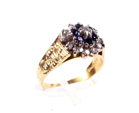 A vintage 18ct gold, sapphire and diamond tiered-cluster ring. Centred with a small round brilliant diamond within a dark-blu