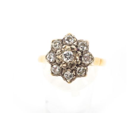 A mid-20th century gold and diamond cluster ring. The nine round brilliants approx. 0.76cts total, grain and illusion set to 