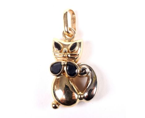 A vintage bi-colour metal and sapphire pendant in the form of a seated Siamese cat. Of stylised form, with two marquise black