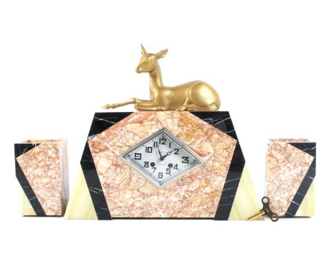 A French Art Deco marble and onyx mounted three piece clock garniture. The shaped rectangular mantel clock surmounted by a gi