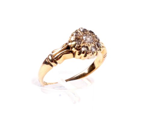 A late Victorian 18ct gold and diamond cluster ring. Centred with a small old-cut diamond within a rose diamond eight stone b