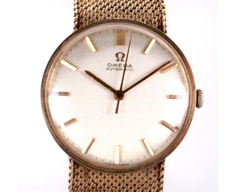 A vintage gents 9ct gold Omega automatic wristwatch. The silvered dial with gilt baton markers denoting hours, on 9ct gold me