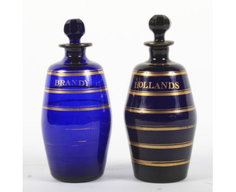 Two Regency Bristol blue barrel-shaped decanters and stoppers. Named in gilt for Hollands and Brandy within gilt concentric b