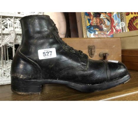 An old army issue black leather boot with wooden infill to repurpose as a doorstop