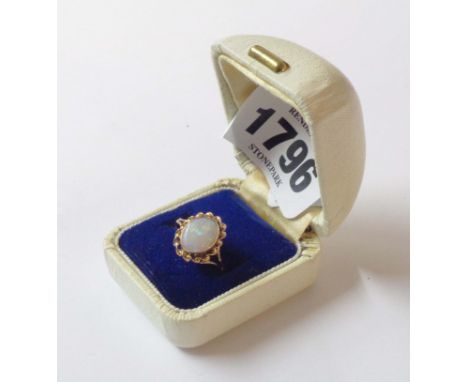 A 375 (9ct.) gold ring, set with central oval opal within a twist border - size N 1/2 - boxed