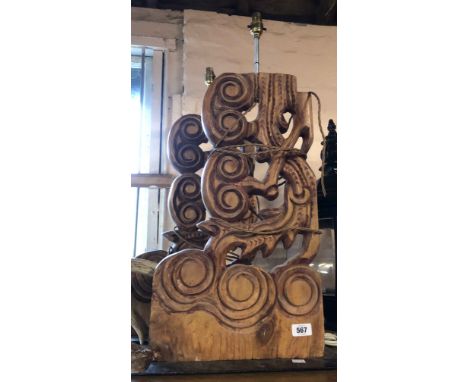 A pair of large carved wooden table lamps with pierced scroll and swirl decoration set on metal bases