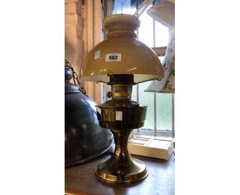 A vintage Aladdin brass oil lamp with clear glass chimney and amber opaque glass shade