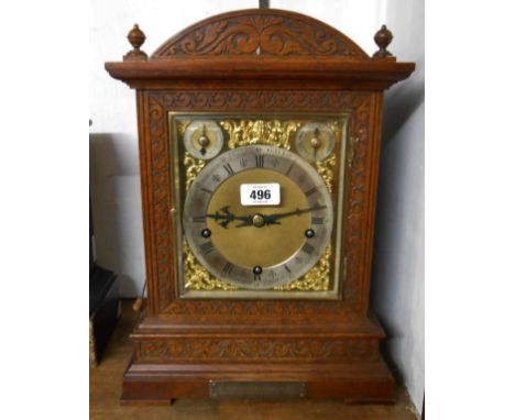 A late 19th Century ornate carved oak cased table clock with brass and silvered dial marked for retailer's Camerer &amp; Cuss