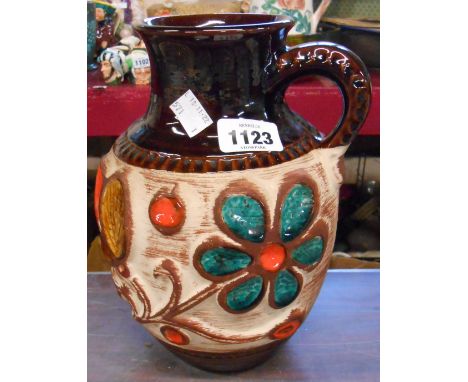 A vintage West German Bay Pottery vase of single handled form with heavily embossed floral decoration and inset coloured glaz