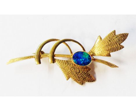 A marked 9ct yellow metal stylised leaf pattern brooch, set with oval doublet opal panel