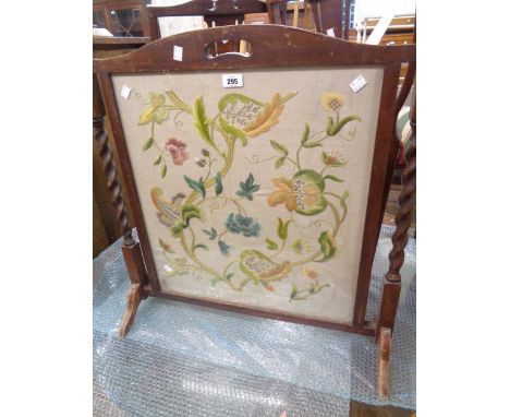 An old oak framed firescreen with flanking barley twist pillars and woolwork panel under glass