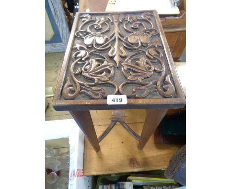 A 35cm stained mixed wood occasional table with decorative carved panel top, set on slender supports and scroll stretcher