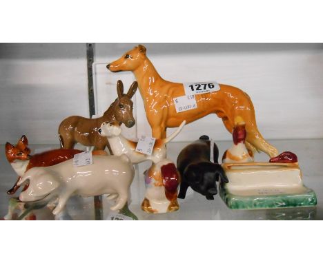 A selection of animal figurines comprising Beswick Jovial Roger greyhound, donkey, fox and foxhound, two Royal Dux pig figuri