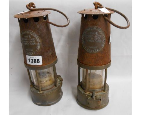 A pair of old brass and steel miner's safety lamps with plaques for The Protector Lamp and Lighting Co. Ltd. of Eccles