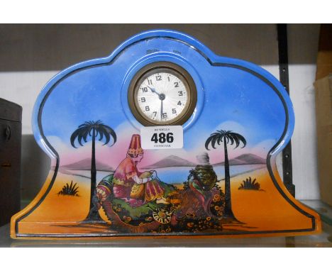 A 1920's decorative ceramic cased timepiece with printed polychrome dessert oasis scene and simple thirty hour movement
