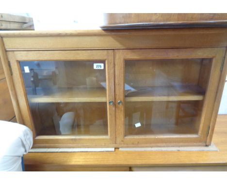 An 87cm vintage polished oak cabinet enclosed by a pair of glazed panel doors