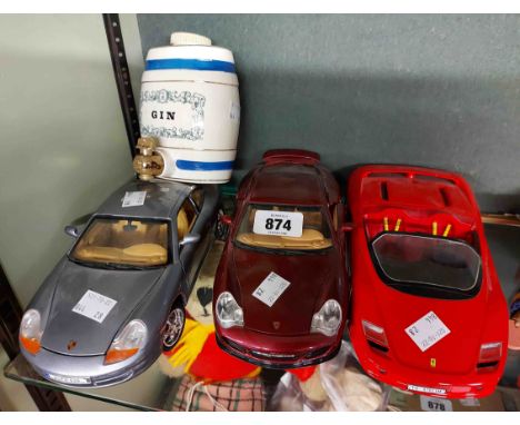 Three large diecast model cars comprising a Burago Porsche 996 Turbo, a Ferrari Mythos and a Porsche 911 - sold with a small 