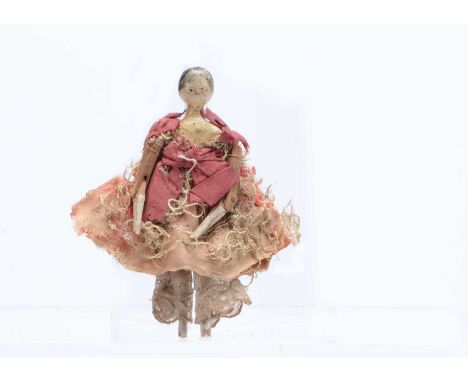 An 19th century Grodnerthal dolls’ house doll, with black painted centre-parted hair, jointed wooden body and pink dress with